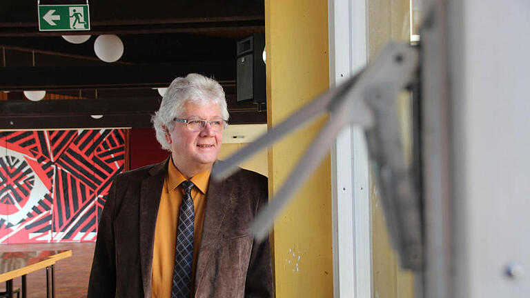 Schulleiter Helmut Schreiner in der Aula des Frobenius-Gymnasiums. Fenster und Fassade sind noch aus den 1960er Jahren.  Foto: Benedikt Borst       -  Schulleiter Helmut Schreiner in der Aula des Frobenius-Gymnasiums. Fenster und Fassade sind noch aus den 1960er Jahren.  Foto: Benedikt Borst