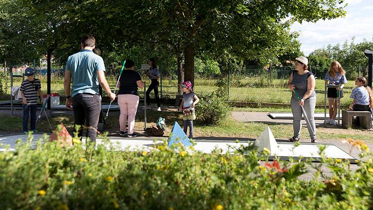 Zahlreiche Menschen tummeln sich auf der Minigolfanlage in Veitshöchheim.