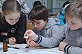 Ein Schüler drückt vorsichtig einen Wassertropfen aus einer Pipette auf eine rußbeschichtete Glasplatte: Die sechsten Klassen am&nbsp;Matthias-Grünewald-Gymnasium gaben bei einer Bionik-Veranstaltung ihr Wissen an die vierten Klassen der Grundschule am Schloss weiter.