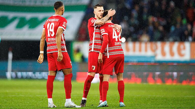 Felix Uduokhai (von links), Jeffrey Gouweleeuw und Aaron Zehnter vom FC Augsburg feiern am Freitagabend ihren Sieg in der Fußball-Bundesliga über Leverkusen.