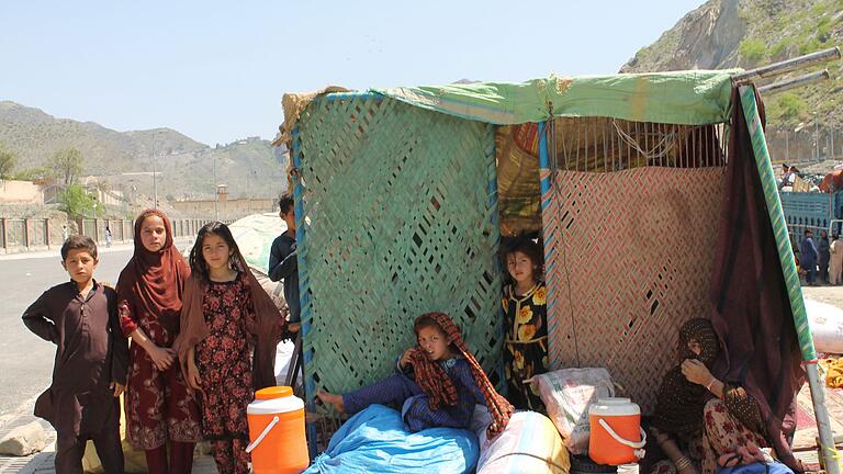 Pakistan schiebt Afghanen ab       -  Afghanische Flüchtlinge sitzen mit ihren Habseligkeiten am Grenzübergang Torkham. (Archivbild)