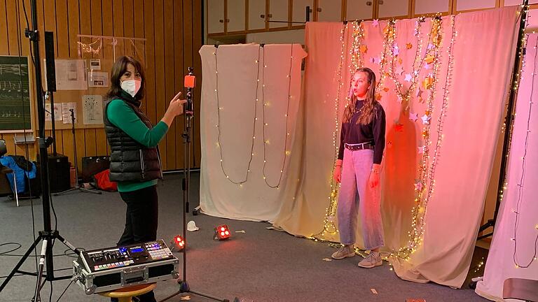 Jede der acht Schülerinnen der Pop-Gesangsklasse der Musikschule erschien einzeln zum Dreh und zum Einsingen ihres Beitrages für den Weihnachtssong 'That's Christmas to me'. Hier ist es Antonia Kohlhepp, die gemeinsam mit Gesangslehrerin Canan Semel in einem Mix aus Weihnachtskulisse und Studio-Atmosphäre, der in der Musikschule aufgebaut wurde, ihren Teil einsingt. Jede der acht Schülerinnen der Pop-Gesangsklasse der Musikschule erschien einzeln zum Dreh und zum Einsingen ihres Beitrages für den Weihnachtssong 'That's Christmas to me'. Hier ist es Antonia Kohlhepp, die gemeinsam mit Gesangslehrerin Canan Semel in einem Mix aus Weihnachtskulisse und Studio-Atmosphäre, der in der Musikschule aufgebaut wurde, ihren Teil einsingt.