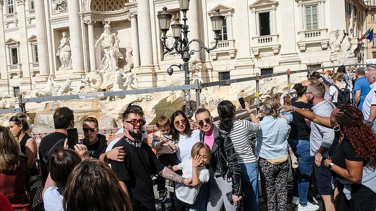 Restaurierung des Trevi-Brunnens in Rom       -  Touristen am Trevi-Brunnen - Massentourismus ist ein großes Problem in Italien. (Archivbild)