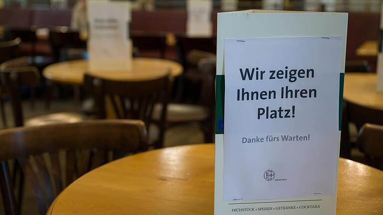 Schilder, die über die Zuweisung zu den Plätzen informieren, stehen auf den Tischen eines Restaurants (Symbolbild).&nbsp;Seit dem 18. Mai dürfen Gaststätten in Bayern mit Einschränkungen außen, seit dem 25. Mai auch im Innenbereich wieder öffnen. Welche Bilanz ziehen Gastronomen in Bad Neustadt seit der Wiedereröffnung?