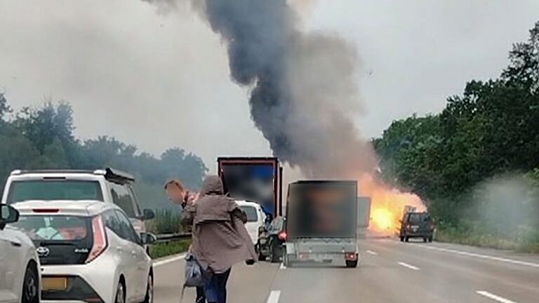 A2.jpeg - Autofahrer verlassen ihre Fahrzeuge, während im Hintergrund ein Lkw in Flammen steht. Nach einem Auffahrunfall sind auf einem Gefahrguttransporter mehrere Gasflaschen explodiert. A2.jpeg - Autofahrer verlassen ihre Fahrzeuge, während im Hintergrund ein Lkw in Flammen steht. Nach einem Auffahrunfall sind auf einem Gefahrguttransporter mehrere Gasflaschen explodiert.