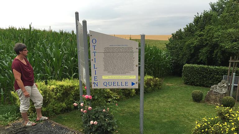 Ottilienquelle in Pfahlenheim: Diese Tafel gibt Infos über die Heilige Ottilie, eine kleine Grünanlage lädt zur Rast ein.