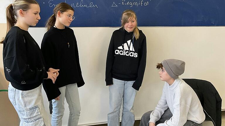 Einige Schülerinnen konfrontieren im Rollenspiel einen 'Mitschüler' wegen seiner gemeinen Textnachricht auf dem Handy. Einige Schülerinnen konfrontieren im Rollenspiel einen 'Mitschüler' wegen seiner gemeinen Textnachricht auf dem Handy.