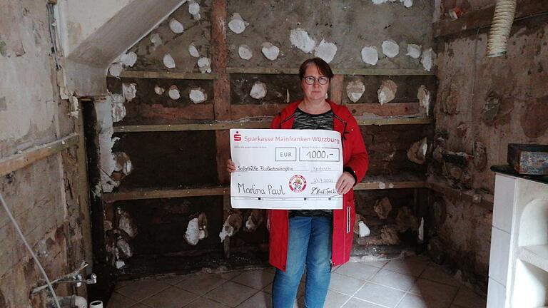 Die Hochwassergeschädigte Martina Paul aus Schleiden, im Kreis Euskirchen, Nordrheinwestfalen freut sich über die Spende des FCB aus dem Fränkischen. Die Hochwassergeschädigte Martina Paul aus Schleiden, im Kreis Euskirchen, Nordrheinwestfalen freut sich über die Spende des FCB aus dem Fränkischen.