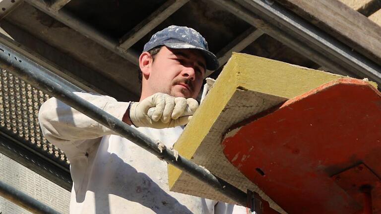 Ein Verputzer bringt den Vollwärmeschutz an der Fassade eines Gewo-Gebäudes an. Foto: Benedikt Borst       -  Ein Verputzer bringt den Vollwärmeschutz an der Fassade eines Gewo-Gebäudes an. Foto: Benedikt Borst