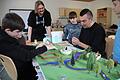 Karsten Müller (hinten links) und David Polotzek (rechts) arbeiten mit den Kindern an ihrem Steinzeitmodell, das im Rahmen des &bdquo;talentCAMPus&ldquo;-Ferienprogramms in Bad Königshofen entsteht.