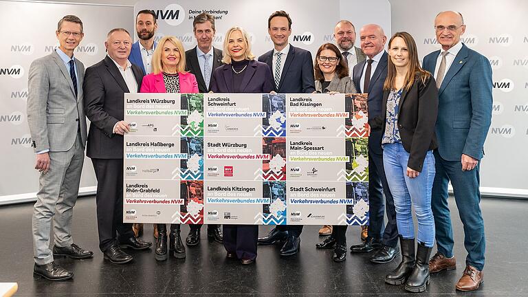 Aufstellung fürs Foto zum Start des neuen Verkehrsverbunds in Mainfranken: (v.li.) Schweinfurts OB Sebastian Remelé, Landrat Thomas Bold aus Bad Kissingen, NVM-Geschäftsführer Christopher Alm, Kitzingens Landrätin Tamara Bischof, Würzburgs OB Christian Schuchardt, Regierungspräsidentin Dr. Susanne Weizendörfer, Schweinfurts Landrat Florian Töpper, Main-Spessart-Landrätin Sabine Sitter, Würzburgs Landrat Thomas Eberth, Landrat Thomas Habermann aus Rhön-Grabfeld, Juliane Chamberlain und Haßberge-Landrat Wilhelm Schneider. Aufstellung fürs Foto zum Start des neuen Verkehrsverbunds in Mainfranken: (v.li.) Schweinfurts OB Sebastian Remelé, Landrat Thomas Bold aus Bad Kissingen, NVM-Geschäftsführer Christopher Alm, Kitzingens Landrätin Tamara Bischof, Würzburgs OB Christian Schuchardt, Regierungspräsidentin Dr. Susanne Weizendörfer, Schweinfurts Landrat Florian Töpper, Main-Spessart-Landrätin Sabine Sitter, Würzburgs Landrat Thomas Eberth, Landrat Thomas Habermann aus Rhön-Grabfeld, Juliane Chamberlain und Haßberge-Landrat Wilhelm Schneider. 