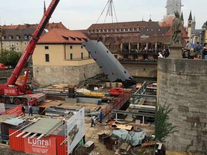 Einheben einer neuen Fischbauchklappe unter der alten Mainbrücke an der Wehranlage Würzburg.