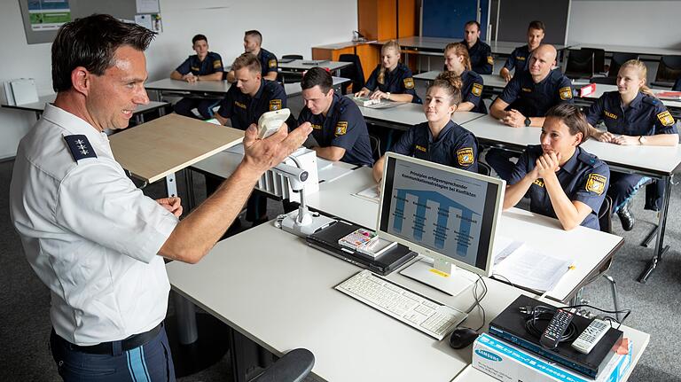 Polizeischüler verfolgen im Rahmen ihrer Ausbildung am Ausbildungsstandort der Bereitschaftspolizei III. Abteilung Würzburg den Unterricht von Nicki Bauer (l), Polizeihauptkommissar und Ausbilder für Einsatzkommunikation.