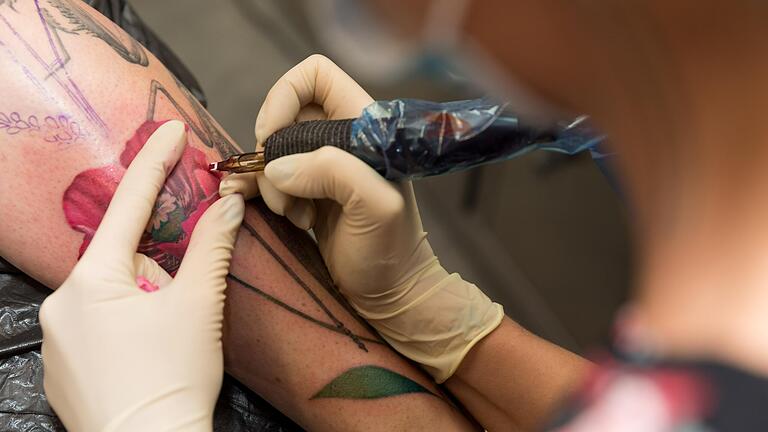 Carolin Dell lässt sich von Tätowiererin Lisa Smith im Tattoo-Studio Andy Engel in Marksteft (Lkr. Kitzingen) ein Tattoo anfertigen.