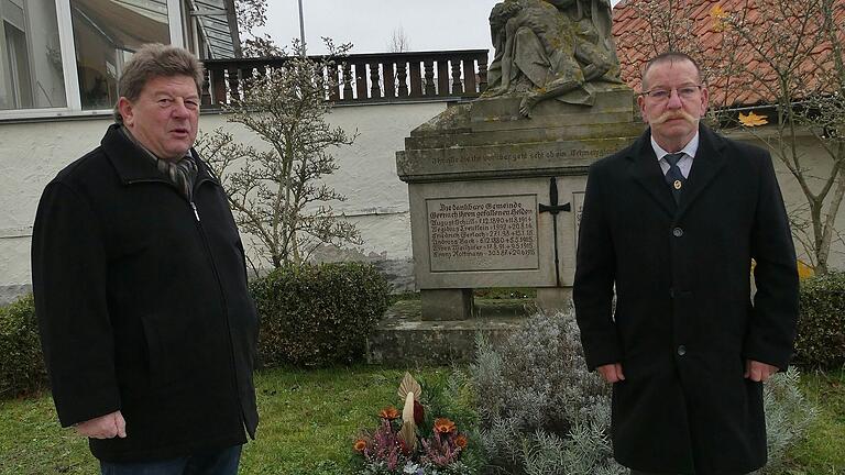 Die beiden Gernacher Gemeinderäte Reinhard Heck (links) und Dieter Dietz legen im Namen der Gemeinde Kolitzheim ein Gebinde am Kriegerdenkmal für die Gefallenen des Ersten Weltkrieges nieder.