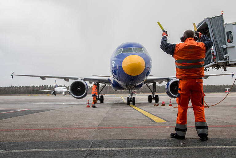 Hier geht es lang: Vorfeldmitarbeiter beim Einwinken des Flugzeuges.