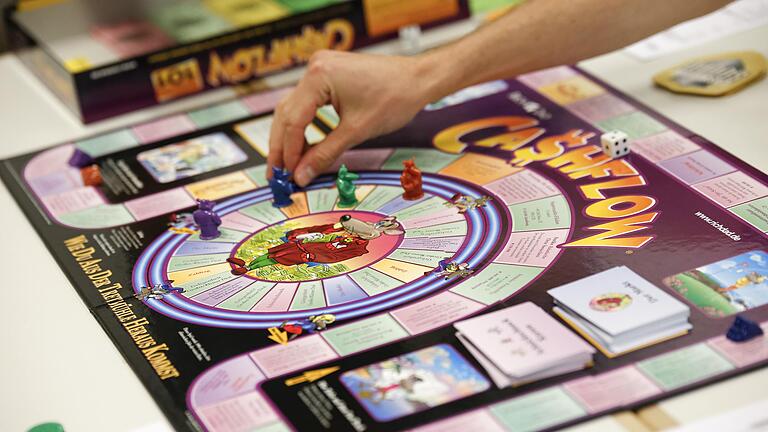 Das Brettspiel 'Cashflow' soll Spielern zu Vermögen verhelfen und finanzielle Fähigkeiten trainieren. Knapp 30 Teilnehmer treffen sich dafür einmal im Monat in der Kolping-Akademie in Würzburg.