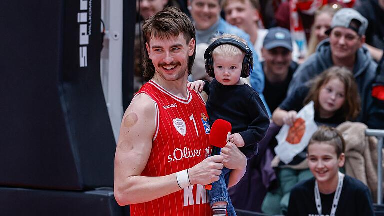 Zac Seljaas feierte nach seiner Top-Leistung mit einem seiner beiden Söhne den Sieg der Würzburg Baskets gegen Alba Berlin.