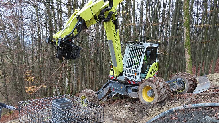 Die Arbeiten an den Kreuzbergschanzen laufen.
Der Steigebagger erleichtert die Arbeiten am Steilhang. Hier hängt der Bewehrungskorb am Tragarm und wird in die Fundamentgrube eingelassen.