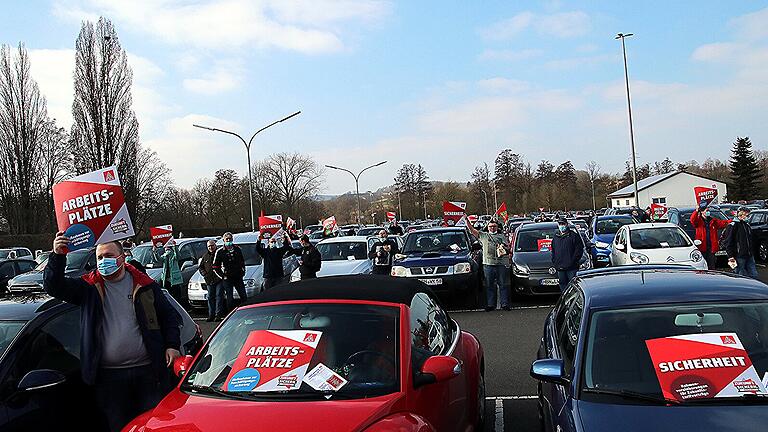 Verteilt auf dem Großparkplatz an der Verteilerspange in Ebern, in und neben ihren Fahrzeugen, Beschäftigte von FTE-Valeo bei der Streikveranstaltung der IG-Metall Bamberg.