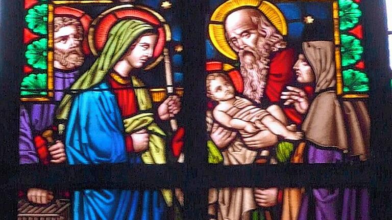 Buntglasfenster in der Pfarrkirche St. Johannes der Täufer in Unterhohenried. Im Nazarener-Stil hat der Künstler die Begegnung der heiligen Familie mit dem greisen Simeon und der Prophetin Hanna im Tempel von Jerusalem nach dem Lukas-Bericht dargestellt.