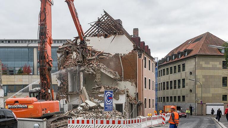 Das erste der drei Häuser ist weg, die beiden anderen sollen in den nächsten vier Wochen folgen. Im Hintergrund (links) der bestehende Sparkassen-Bau in der Hofstraße. Foto: Thomas Obermeier