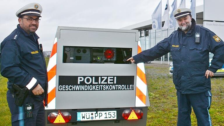 Ingo Stübinger von der Verkehrspolizeiinspektion Schweinfurt (links) und Polizeihauptkommissar Gerd Jahrsdörfer stehen an einem mobilen Blitzer, wie er zwischen Michelau und Geusfeld aufgestellt war. Ingo Stübinger von der Verkehrspolizeiinspektion Schweinfurt (links) und Polizeihauptkommissar Gerd Jahrsdörfer stehen an einem mobilen Blitzer, wie er zwischen Michelau und Geusfeld aufgestellt war.