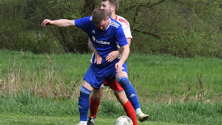 Rhöner Fußball-Nachlese       -  Enge Manndeckung: Ausgebremst sieht sich dieser Akteur der SG Reiterswiesen im Spiel bei der TSVgg Hausen.