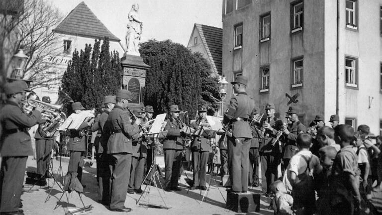 Am 23. August 1936 spielte die Kapelle des hiesigen Reichsarbeitsdienst-Lagers ihr Standkonzert vor dem Denkmal am Marktplatz von Gerolzhofen. Anlass war die Enthüllung des Kriegerdenkmals in der Johanniskapelle für die Gefallenen des Ersten Weltkriegs.