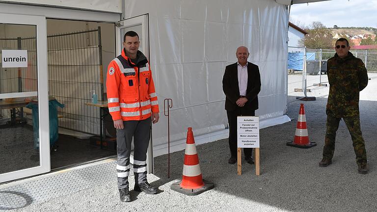 Wo jetzt noch Landrat Thomas Habermann steht, werden ab sofort in der Corona-Teststation in Heustreu die Rachenabstriche genommen. Auf dem Bild sind zudem Alexander Klamt vom BRK Kreisverband Rhön-Grabfeld (links) und Christian Moritz, Leiter des ständigen Kreisverbindungskommandos der Bundeswehr in Rhön-Grabfeld (rechts) zu sehen.&nbsp;