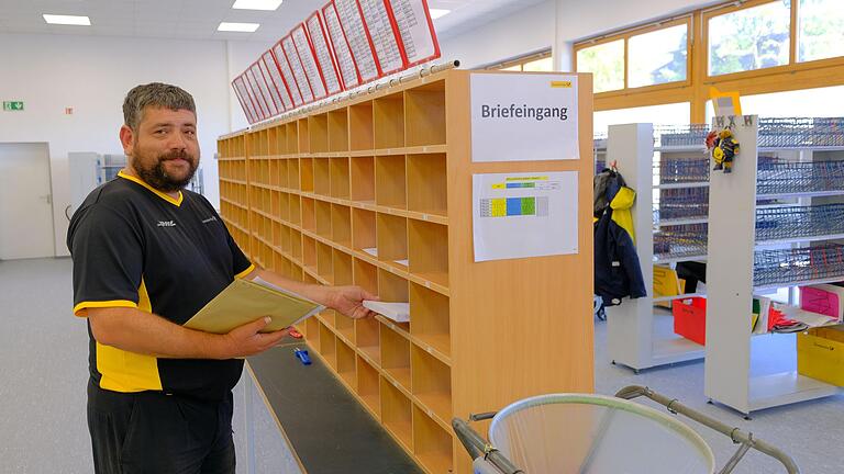 Freude über bessere Arbeitsbedingungen am neuen Standort: Tino Schärpf sortiert im  neuen Zustellstützpunkt Hammelburg Briefe.