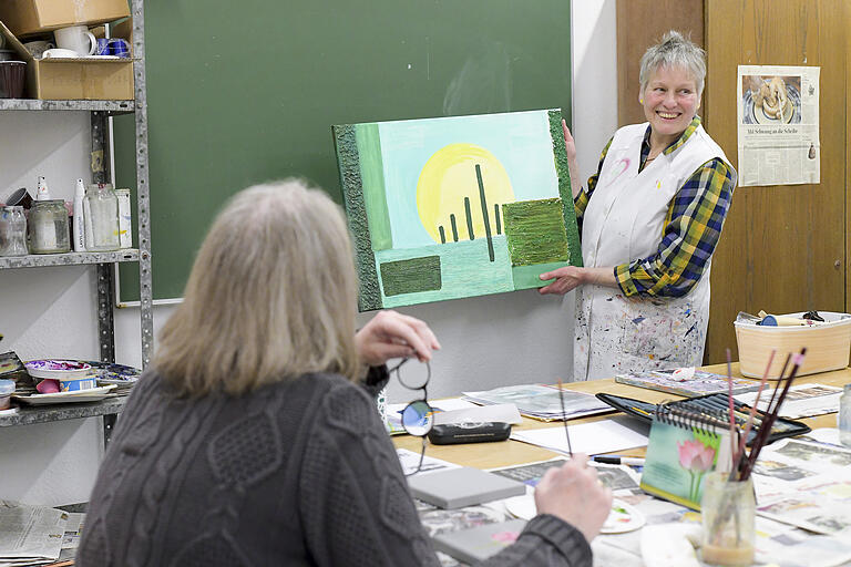 Kursleiterin Gabriele Schaller-Götsch zeigt der Gruppe ein Bild von Waltraud Kirch, die sich nicht sicher war, wie sie am besten weitermachen soll. Gemeinsam finden sie eine Lösung.