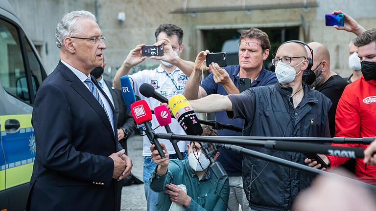 Journalisten&nbsp; interviewen den bayerischen Innenminister Herrmann kurz nach der Messerattacke.