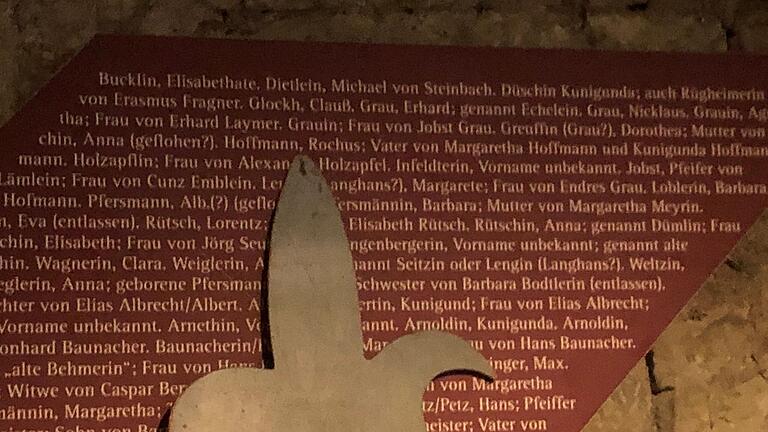 Auf der roten Tafel stehen die Namen derer, die ihr Leben verloren haben, weil sie als Hexe bezichtigt wurden. Die Spitze der Lanze zeigt auf Rochus Hofmann.&nbsp;