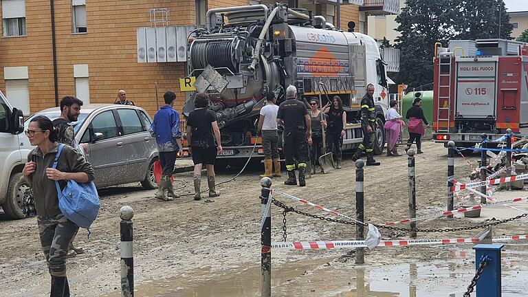 Italien Überschwemmung.jpg       -  Menschen und Helfer sind auf einer Straße zu sehen, die überschwemmt wurde. Nach den dramatischen Überschwemmungen wegen heftiger Regenfälle in der italienischen Region Emilia-Romagna gibt es noch immer keine Entwarnung.