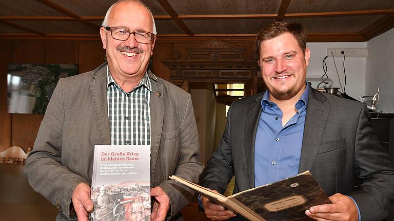 Bürgermeister Bernhard Rhein (links) mit dem Buch, für das Historiker Georg Menig Hunderte von Gemeindeakten und Feldpostbriefen aus der Zeit des Ersten Weltkriegs ausgewertet hat. Foto: Gerhard Meißner