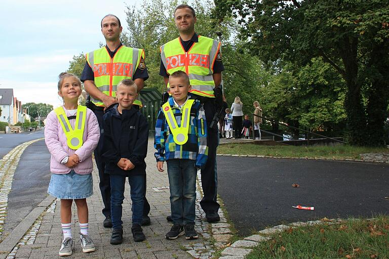 Die Polizisten Michael Kraft (hinten von links) und Timmy Tölk erklärten den Kindern, wie wichtig es ist, im Straßenverkehr gut erkannt zu werden. Die Polizisten Michael Kraft (hinten von links) und Timmy Tölk erklärten den Kindern, wie wichtig es ist, im Straßenverkehr gut erkannt zu werden.