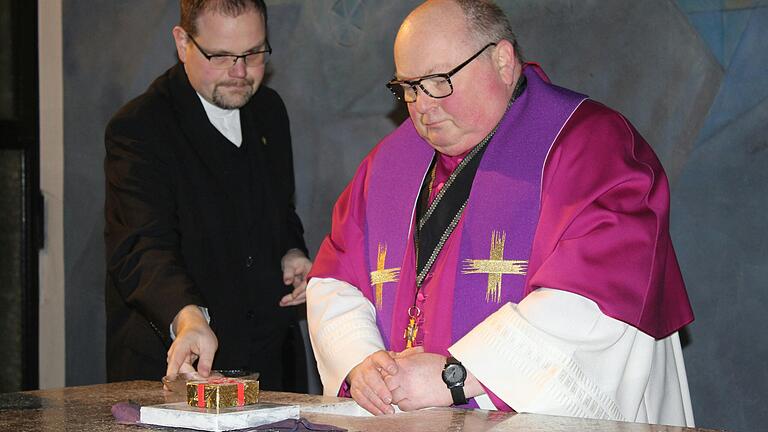 Domkapitular Stefan Geßner (rechts) nahm, begleitet von Pfarrer Matthias Eller, bei der Profanierung der katholischen Kirche in Rüdenhausen die eingelassenen Reliquien aus dem Altar.