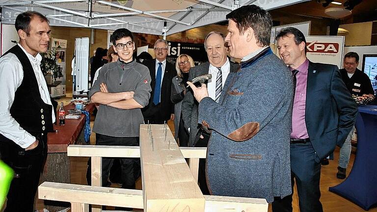 Herausforderung angenommen: Beim Rundgang durch die Ausstellung forderte Steffen Vogel, MdL, Bürgermeister Thomas Helbling dazu auf, den Nagel am Stand der Firma Wentorf-Bulheller mit der spitzen Seite reinzuschlagen, was am Ende auch gelang.