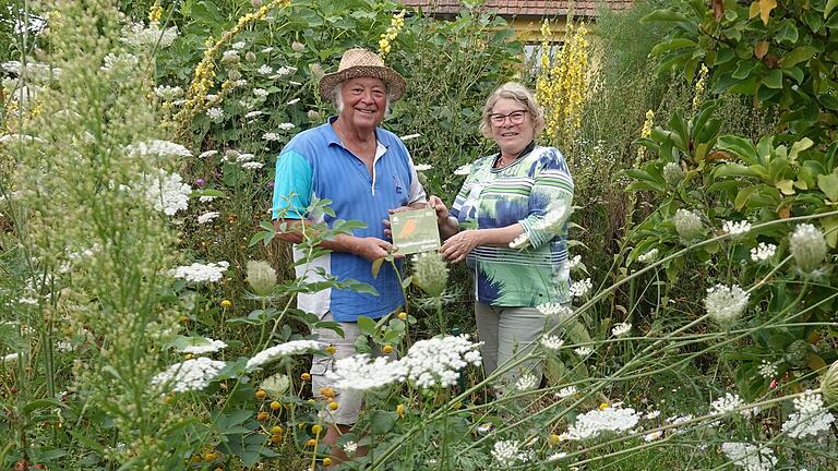 Inmitten eines Blütenmeeres konnte Gerhard Karl die Plakette 'Vogelfreundlicher Garten' aus  den Händen von Katharina Bauer, LBV Kitzingen, entgegennehmen.