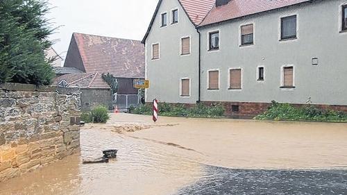 Auch in der Siedlung Am Binsenrain wurde am Abend des Unwetters und danach Nachbarschaftshilfe geleistet. Dort waren mehrere Keller unter Wasser gesetzt worden. Beim Unwetter am 3. Juli entstand dieses Bild an der Kreuzung Am Wasserhaus und Gramschatzer Straße. Vom Berg herunter schoss das Wasser durch die Straßen Hausens.