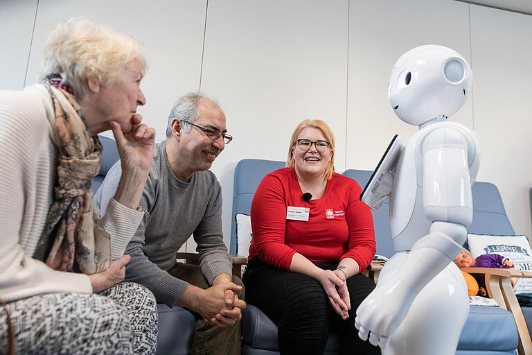 Der Pflegeroboter Pepper hat unter den Gästen der Tagespflege schnell Freunde gefunden. Pflegerin Janine Langner (rechts) unterstützt die Gäste bei ihren ersten Kontakten mit dem Roboter.