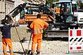 Zwei Bauarbeiter beim Verteilen von Kies an einer Baustelle. Anlieger mussten für den Straßenausbau in der Vergangenheit kräftig mitbezahlen.