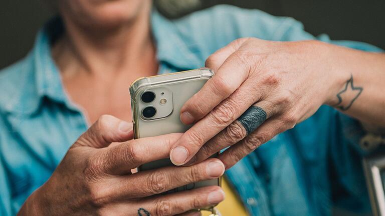 Eine Frau bedient ihr Smartphone.jpeg       -  Beim Tippen auf dem Smartphone kommt man manchmal schnell ins Schwitzen, wenn man Sonderzeichen sucht.