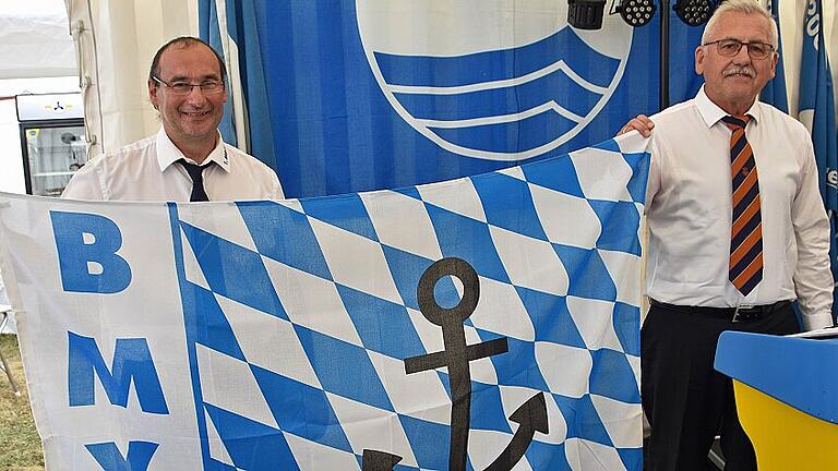 Fritz Lauch, Vizepräsident des Bayerischen Motoryachtverbandes (rechts), überreichte dem Vorsitzenden des 1. Motorbootclubs Obertheres, Bernd Schaufuß, eine neue Flagge des Verbandes.