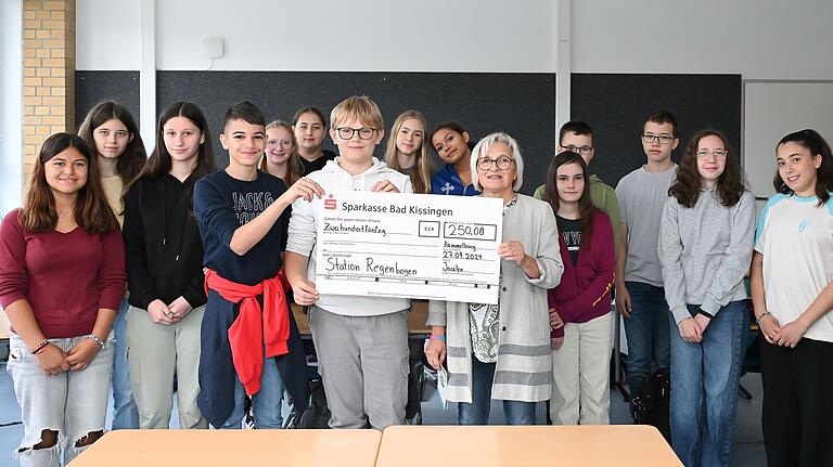 Die Klasse 8cM der Mittelschule Hammelburg übergibt einen Spendenscheck an Andrea Green von der Station Regenbogen in Würzburg.