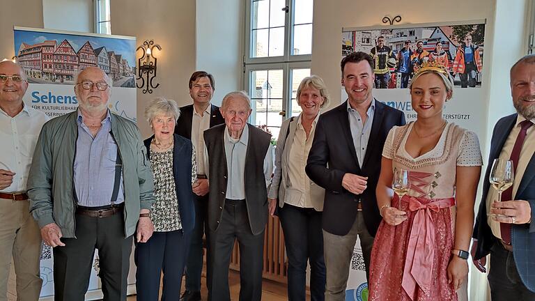 Feiern die Werte des Landkreises zur Eröffnung der Ausstellung „Jeder Moment WERTvoll. 50 Jahre Landkreis Würzburg“ und der kreisangehörigen Stadt Eibelstadt (von links): Stadtrat Manfred Schätzlein, Ehrenbürger Franz Schicklberger, Pfarrhaushälterin Rita Hippeli, Stadtrat Jochen Kunkel, Ehrenbürger Pfarrer Erich Büttner, Stadträtin Dr. Katharina Brandl, Bürgermeister Markus Schenk, Weinprinzessin Alicia I. und Landrat Thomas Eberth.