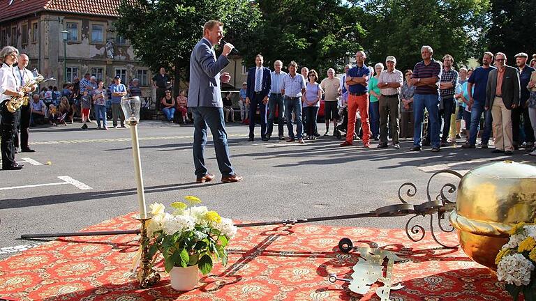 Sonst in luftiger Höhe, hier zum Greifen nahe: Turmkugel, Kreuz und Johannes-Figur. Im Hintergrund begrüßte Bürgermeister Juks die Gäste der Feier zur Kreuzerhöhung.