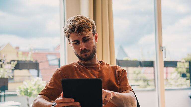 Mann mit Tablet       -  Swipe nach rechts - und bestenfalls ist es ein Match. Für viele ist Online-Dating Alltag.