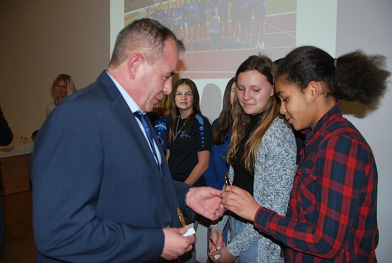 Stellvertretender Landrat Alois Fischer ehrt eine erfolgreiche Sportlerin der Mittelschule Unterpleichfeld.